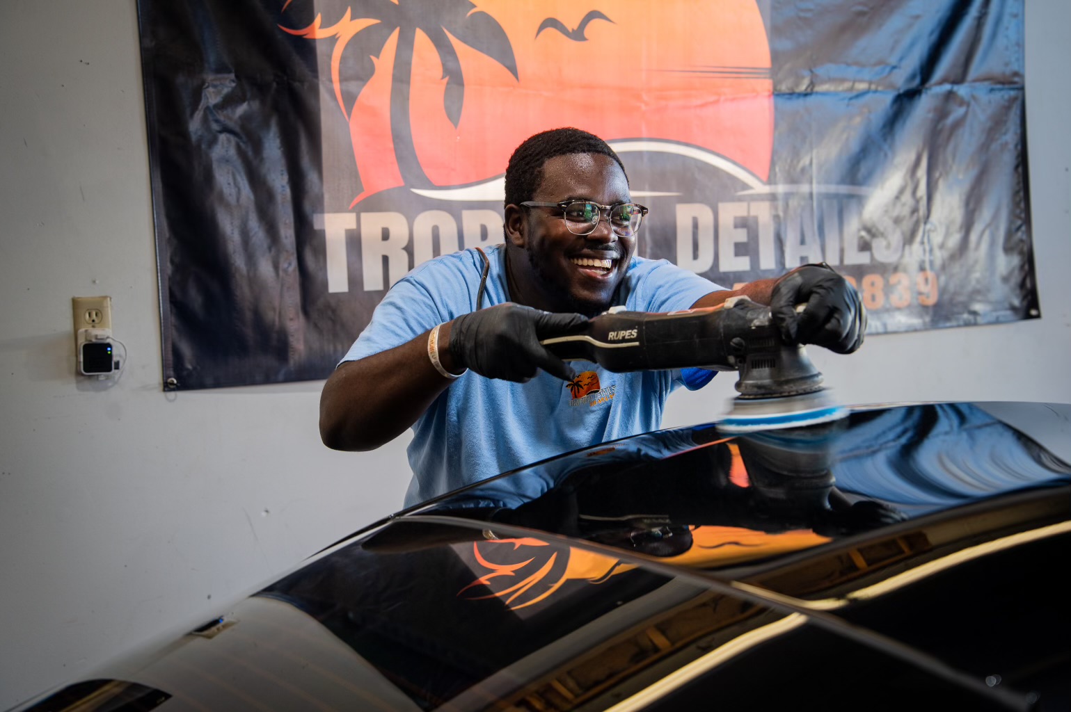 Tropical Details technician machine-polishing a car