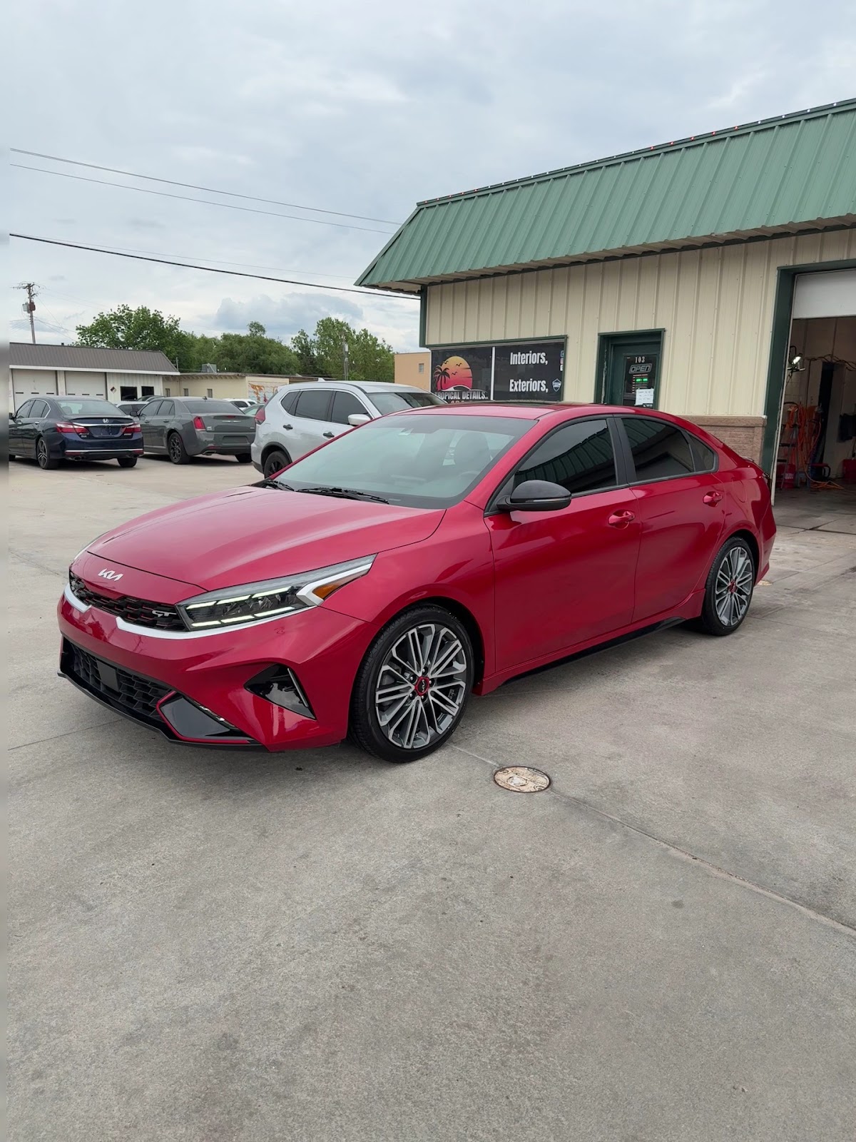 Red Kia Forte GT with fresh window tint outside Tropical Details